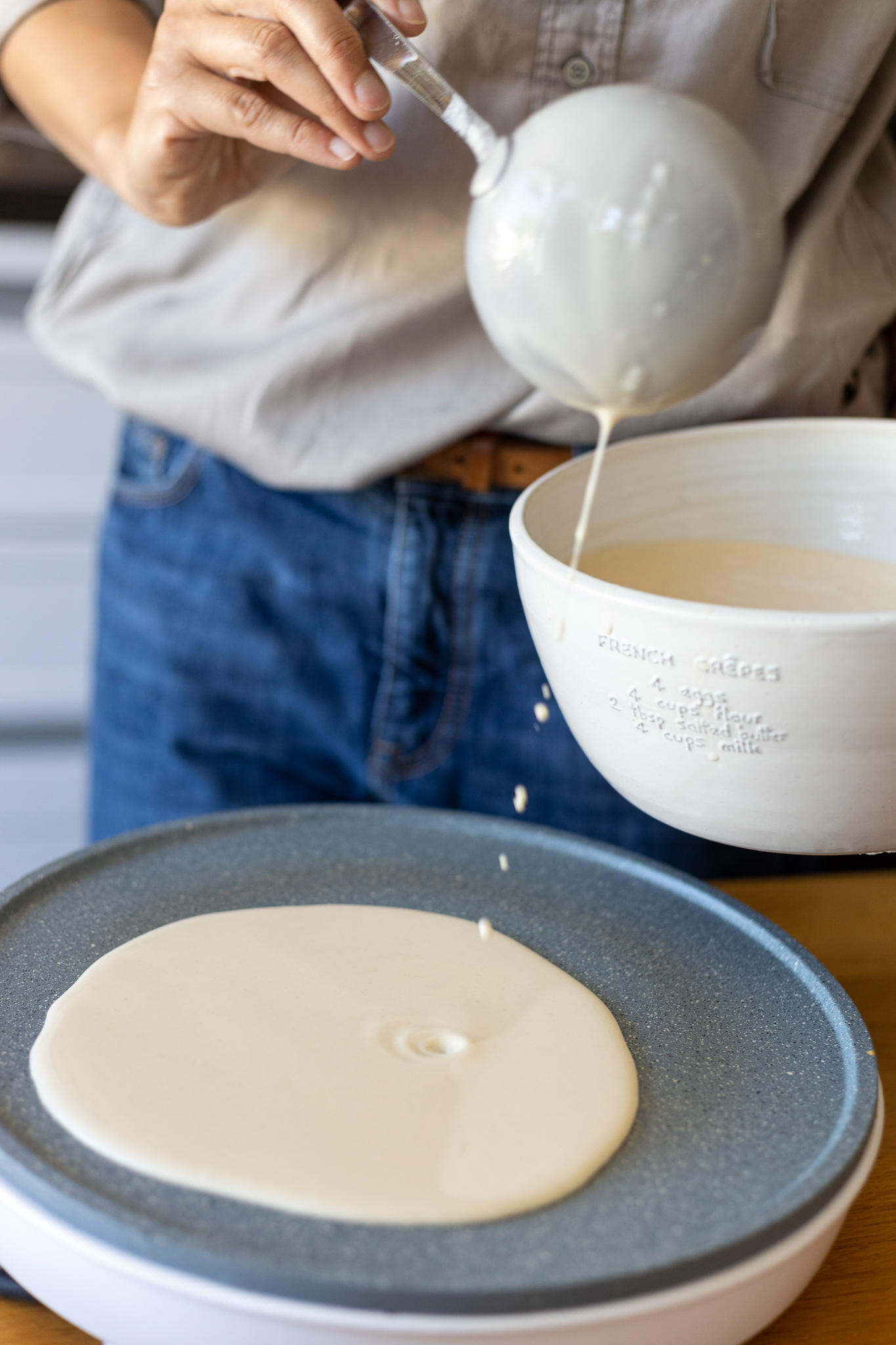 Pouring crepe batter on a stone machine